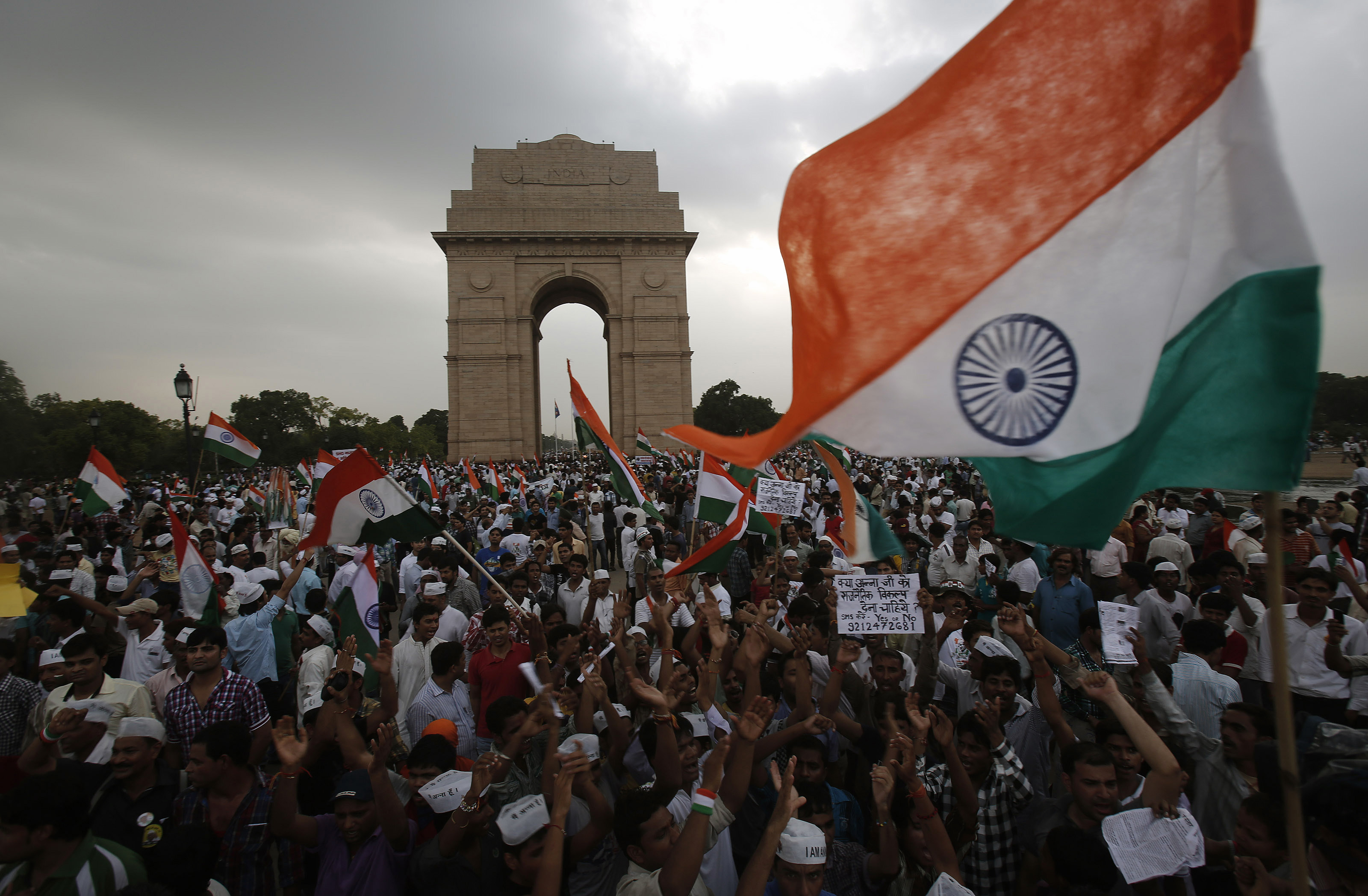 Supporters of veteran Indian social activist Hazare wave India's national flags at the India Gate during a hunger strike by Hazare and his team members in New Delhi