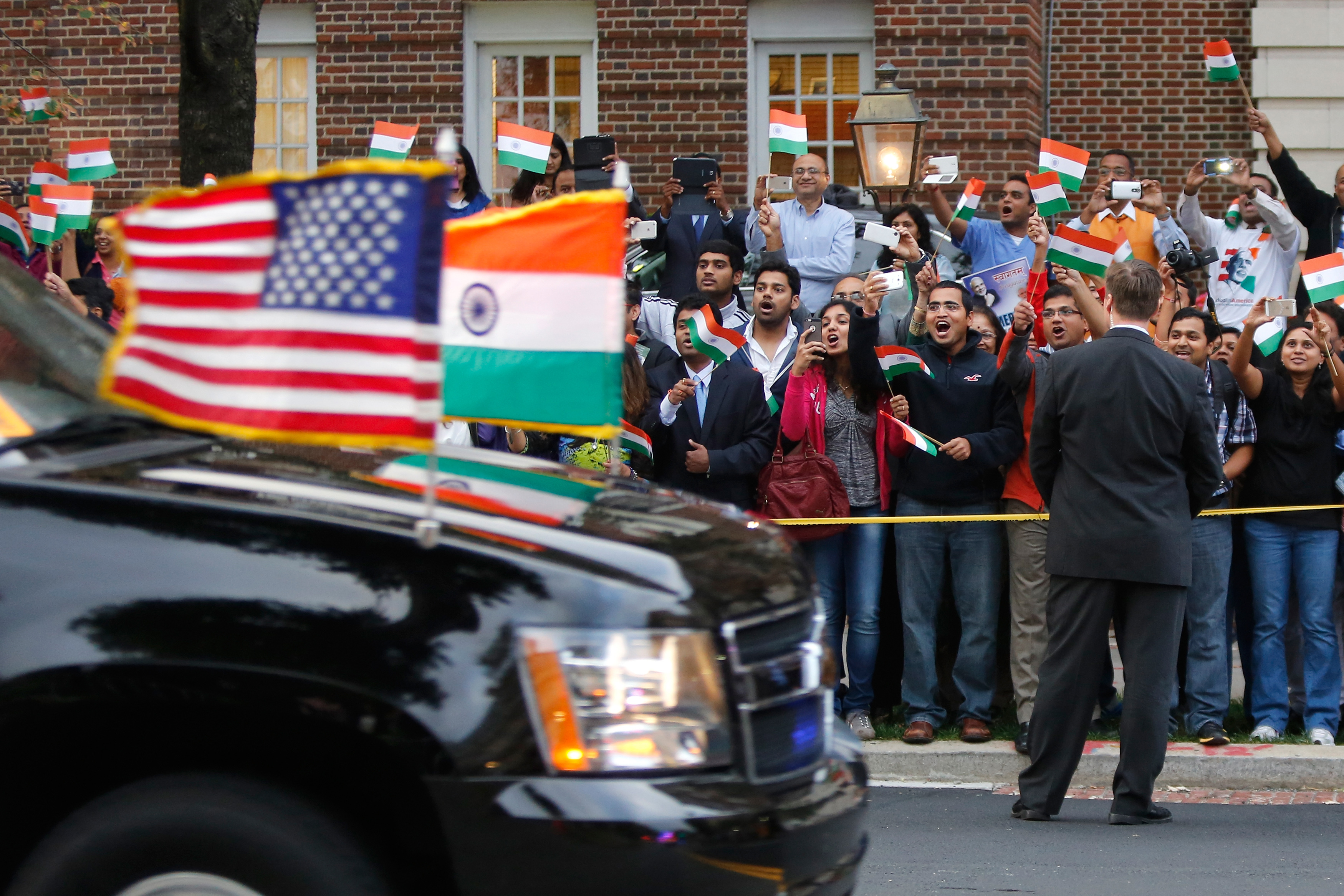 A crowd cheers as the motorcade carrying India's Prime Minister Narendra Modi arrives for him to pay homage at the Mahatma Gandhi Statue in front of the Indian Embassy in Washington September 30, 2014.
