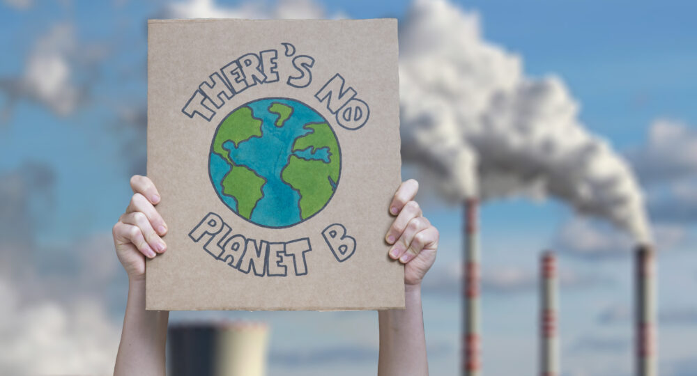 A protestor holds up a sign to protest climate change, which says: There is no Planet B